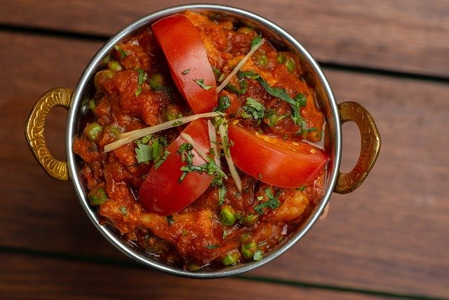 Indian dish of chicken thighs garnished with tomatoes